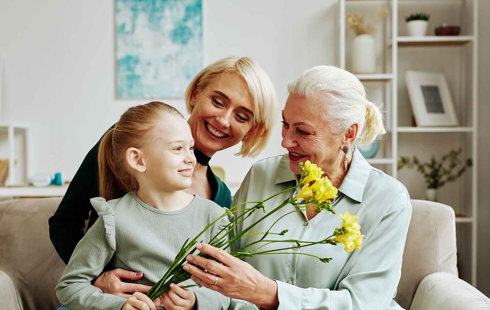 Bedstemor i sofa med barn og barnebarn, med blomster