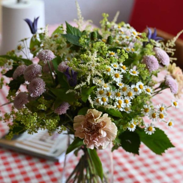 Buket i lyse blomster på ternet dug