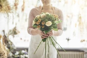 blomsterbinder med buket i hænderne