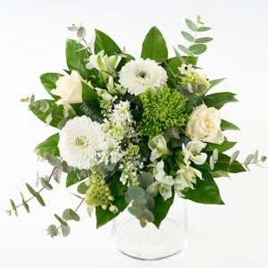 En lav buket bumdet af hvide blomster; roser, gerbera, chrysanthemum, syrener, alstroemeria og grønt.